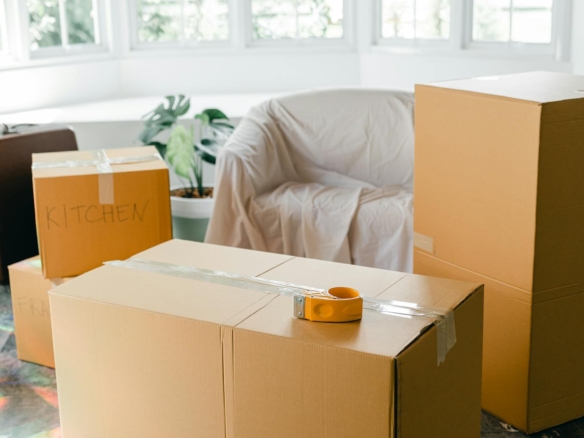 Packed cardboard moving boxes in a bright apartment being vacated at the end of a tenancy in BC