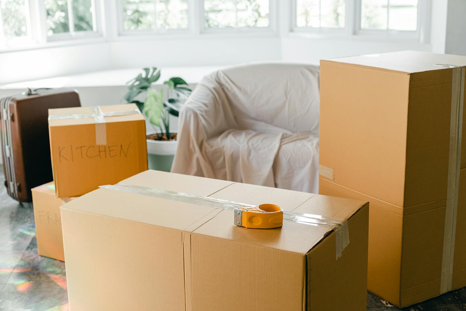 Packed cardboard moving boxes in a bright apartment being vacated at the end of a tenancy in BC
